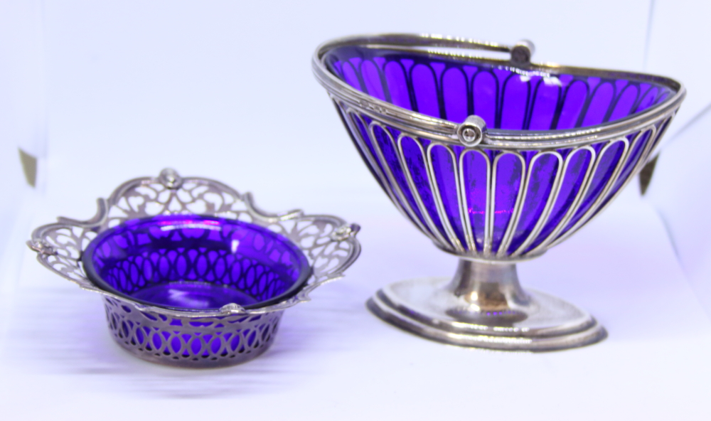 A silver wirework bonbon basket, on oval stand with blue glass liner, 9.9oz troy approx, and one