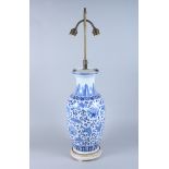 A Chinese porcelain Ming design table lamp with blue peony decoration on a white ground, on hardwood