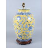 A Chinese porcelain Ming design table lamp with blue and white lotus leaf decoration on a yellow