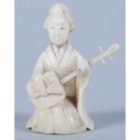 An early 20th century Ivory netsuke of a seated female playing a stringed instrument, 2 1/4" high
