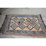 A Caucasian kelim rug decorated eleven lozenge shaped medallions on a brown ground, 89" x 53"