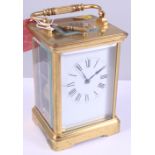 An hour repeater carriage clock with a white enamel dial in brass case, 6" high