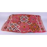 A Moroccan flatweave bag, face with all over geometric design in shades of pink orange black and