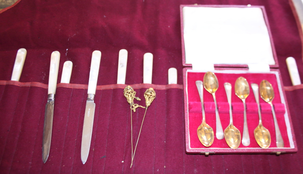 A set of six silver backed and mother-of-pearl handled knives and forks, together with a cased set