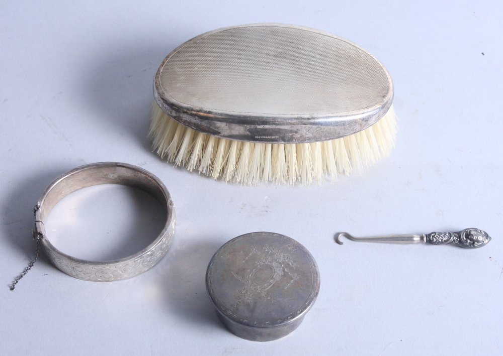 A silver backed clothes brush, a silver trinket box, a silver bracelet and a silver mounted button