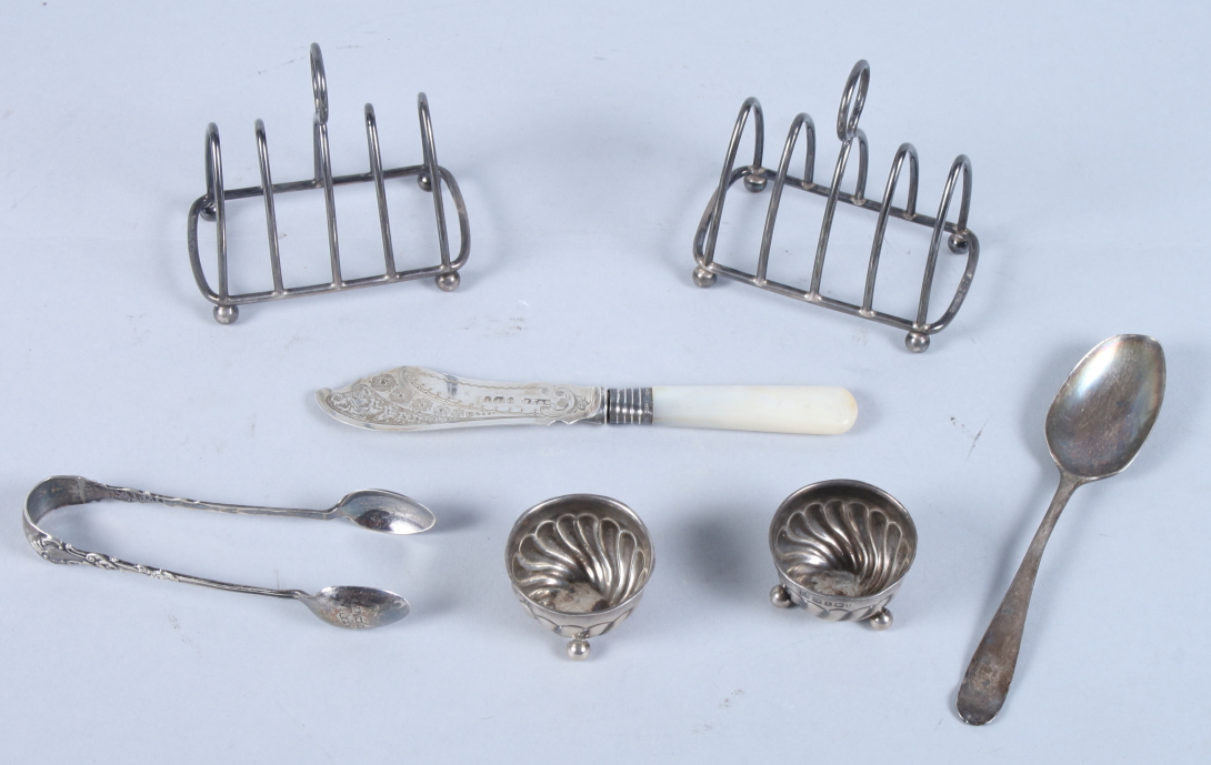 A pair of silver spiral fluted salts, a pair of silver wirework toast racks, a Georgian silver