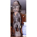 A Polynesian hardwood figure of a standing nude male with orange painted detail to the face and