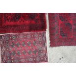 A Bokhara rug with two guls, 52" x 36" approx (worn) and 43" x 47" approx, and a similar rug, 32"