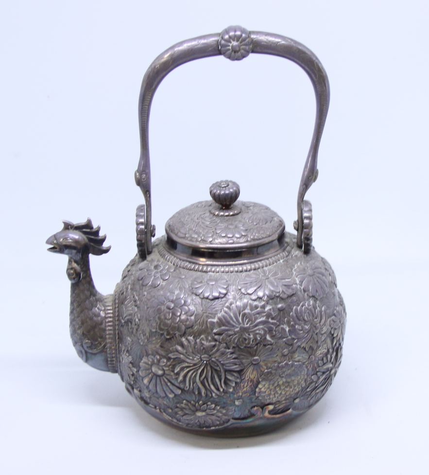 A Japanese white metal teapot with all-over floral decoration and cockerel spout, applied seal