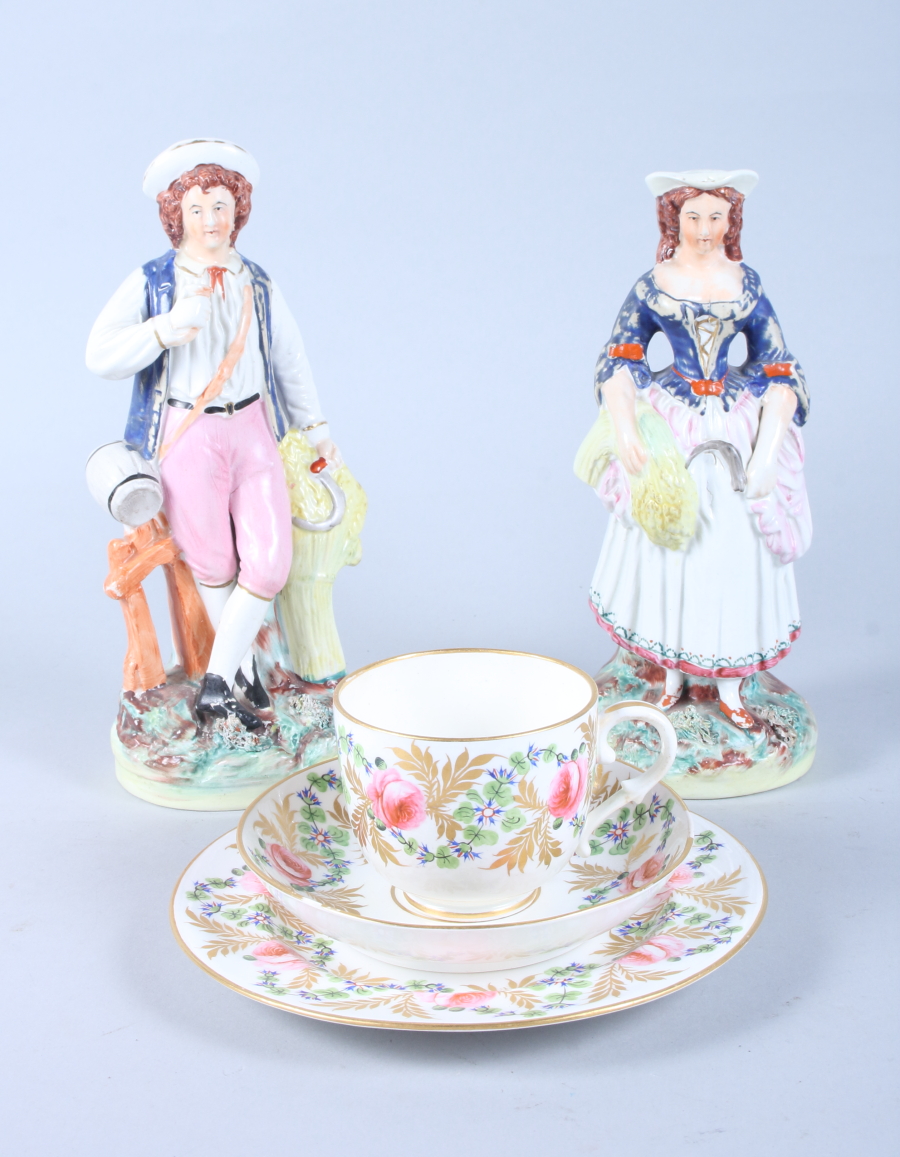 A late Victorian Staffordshire pottery model of a shepherd and shepherdess, 8 1/2" high, and a