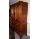 An early 19th century provincial oak linen press, the upper section enclosed arch top panel doors,