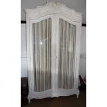 A French 19th century white painted armoire enclosed two glazed doors with pleated fabric backing,