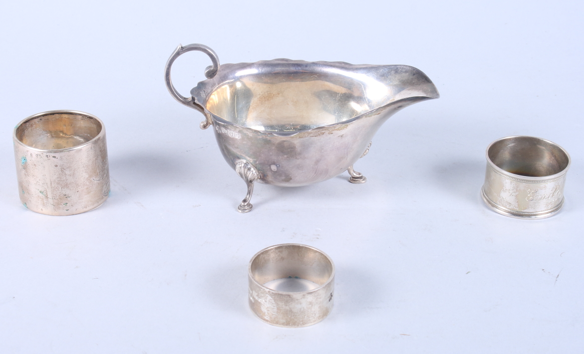 A mid Victorian silver sauceboat with scroll handle, on hoof feet supports, together with three