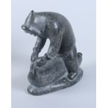 An Inuit mid 20th century hardstone carving of an Inuit hunting a seal, 6 1/4" high