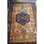 A Persian vase rug with blue central medallion on a sand ground, multi-bordered in shades of red,