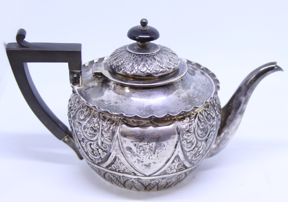 A late Victorian silver teapot with embossed floral and acanthus leaf decoration, composition handle