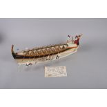 An early 20th century painted wooden scale model of a dhoni rowing boat, 17" long overall, on