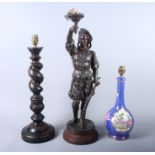 A spelter model of a 17th century soldier, 21" high, a turned oak candlestick table lamp, 19"