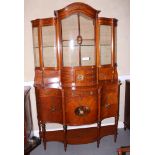 A Sheraton revival painted satinwood serpentine front display cabinet, the upper section with glazed