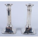 A pair of George V silver candlesticks with octagonal columns, on square bases, 6" high