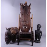 A pair of Indonesian carved wooden masks, 12" high, a Polynesian carved figure with cowry shell