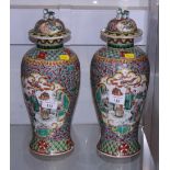 A pair of early 20th century Chinese porcelain vases, decorated with figures in a garden, together