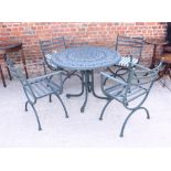 A wrought metal circular garden table together with four 'X' frame chairs with loose cushions