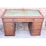 A walnut double pedestal desk with tooled leather top and nine drawers, 47" wide