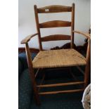 An Arts & Crafts ash ladder back elbow chair with seagrass strung seat, on turned and stretchered
