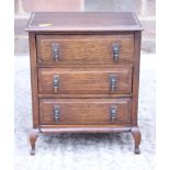 An early 20th century oak chest of three long drawers, on cabriole supports, 9" wide