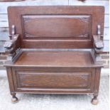 A monk's carved oak box seat bench with lion terminals, on turned supports, 41 1/2" wide