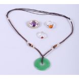 A 19th century amethyst and seed pearl brooch, a jade Pi disk, on necklace, and two silver and amber