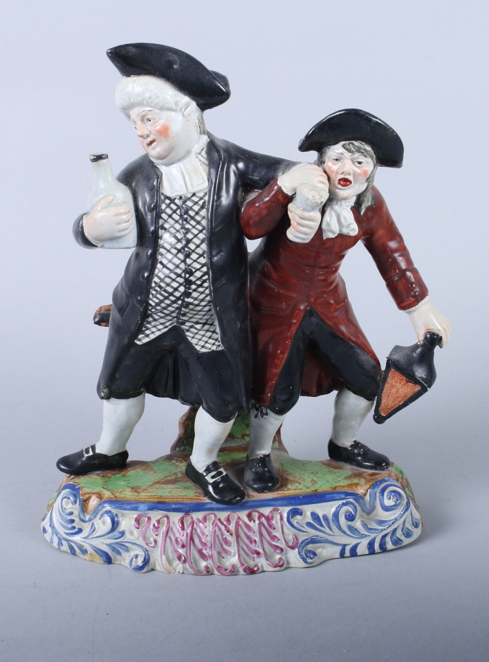 An 18th century Staffordshire model of The Drunken Cleric and his Clerk, on scrollwork base, 9 1/