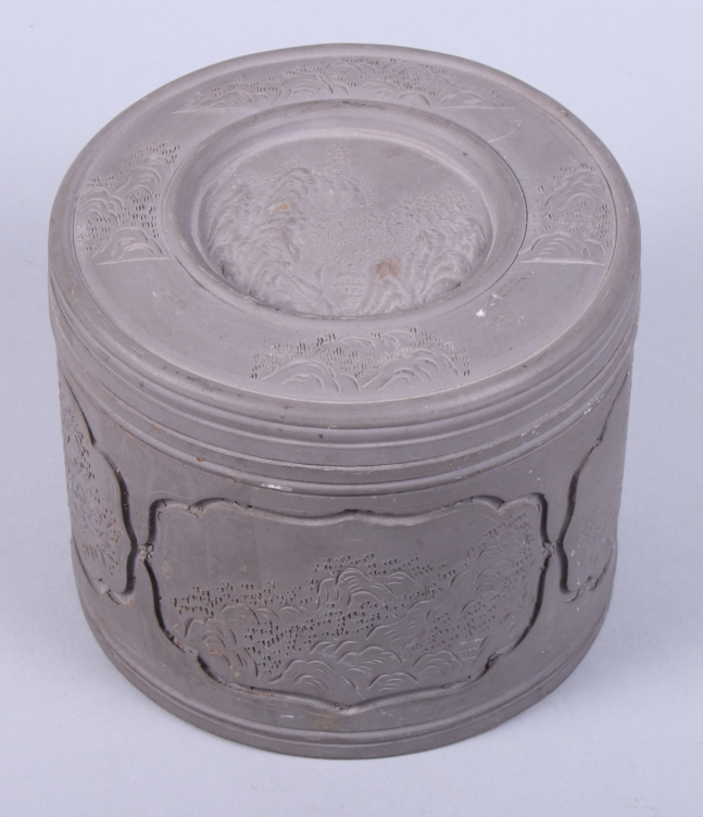 A Chinese Republic period grey stoneware cricket cage, decorated with incised mountain scenes, the