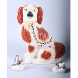 A 19th century Staffordshire spaniel, 12" high, and a pair of 19th century Staffordshire figures,