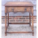 A carved oak side table, fitted one drawer, on turned and stretchered supports, 26" wide