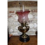 A Victorian brass oil lamp (now converted to electricity) with etched cranberry and clear glass