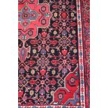 A Persian woollen runner with various symbols, in shades of red, blue and natural, 62" x 24" approx,