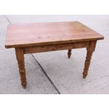 A waxed pine kitchen table, on turned supports, 54" x 55 1/2"