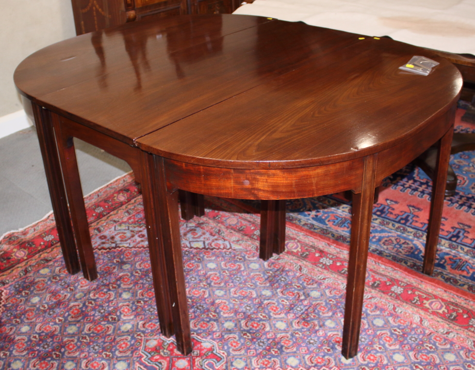 An early 19th century mahogany 'D' end dining table with centre section and two extra leaves, on