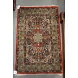 A Kashan silken pile rug with all-over floral design on a red and blue ground, 36" x 23" approx