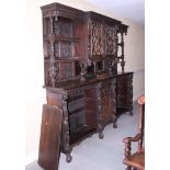 A 19th century carved oak side cabinet/dresser, fitted open shelves and central glazed cupboard over