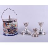 A pottery biscuit barrel with Imari decoration and plated mounts, a pair of silver candlesticks with