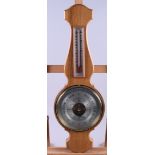 A mid 20th century oak aneroid barometer, complete with instructions, 21" long