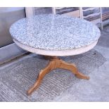 A circular pine dining table with granite top, on tripod splay supports, 43" dia