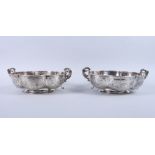 A pair of Georgian silver pedestal fruit bowls of lobed form with engraved and embossed floral