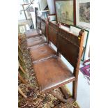 A set of four carved oak standard dining chairs with leather seats and back panels, on cantilever