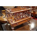 A 19th century walnut canterbury, fitted single drawer, on turned and castored supports, 21" wide