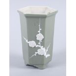 A Chinese porcelain green glazed hexagonal vase, prunus decoration, on stylised feet, 5" high