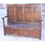 An early 19th century waxed pine box settle with panel, on stile supports, 55" wide